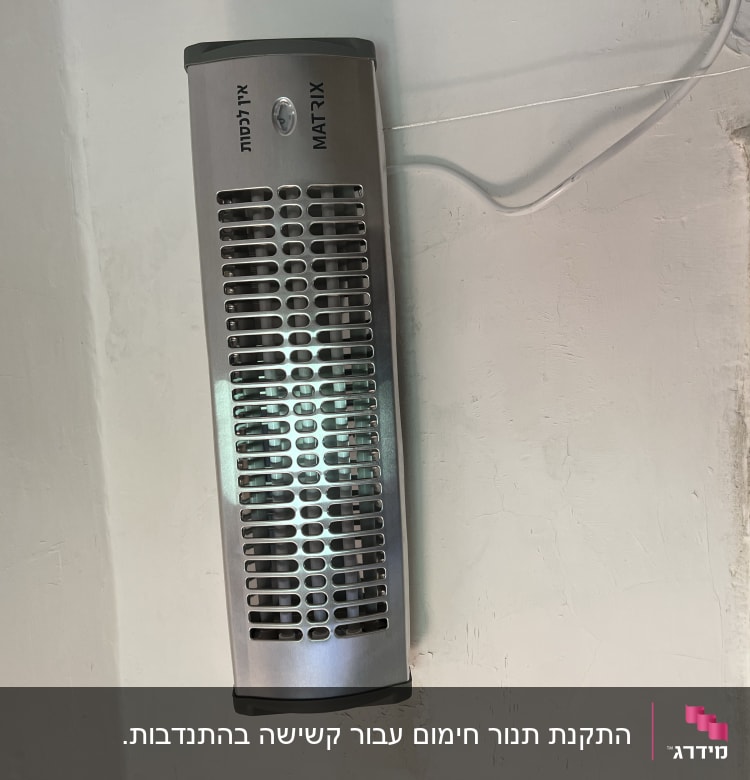 תנור חימום חשמלי מותקן על קיר עם כבל חשמל
